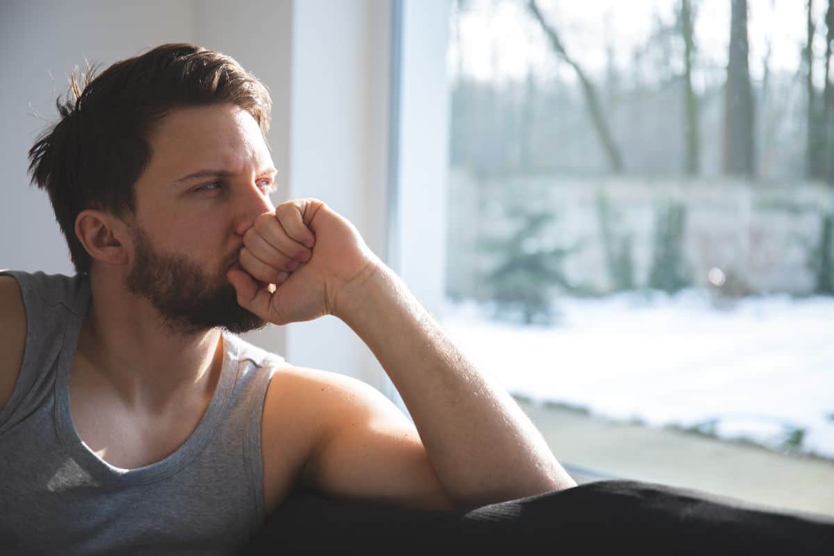 An image of a man looking out a window and contemplating bipolar disorder supportive therapy to assist with symptoms of bipolar disorder. Fullarton Clinic is a private hospital in Melbourne providing bipolar treatment.